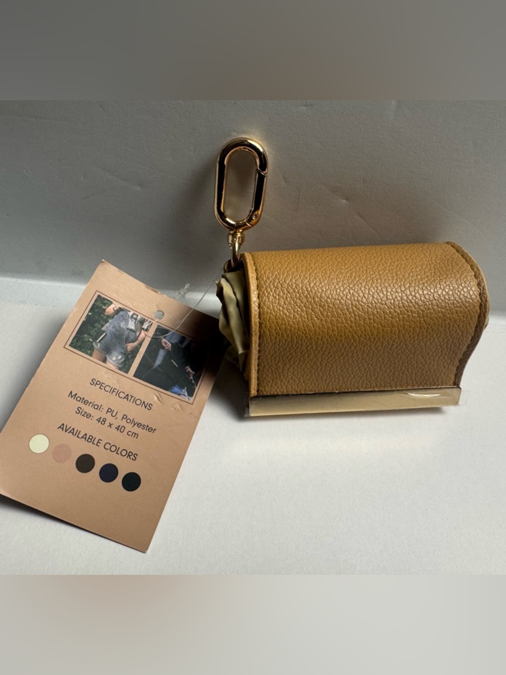 A foldable tote bag charm with carabiner clasp for easy use of reusable bag.